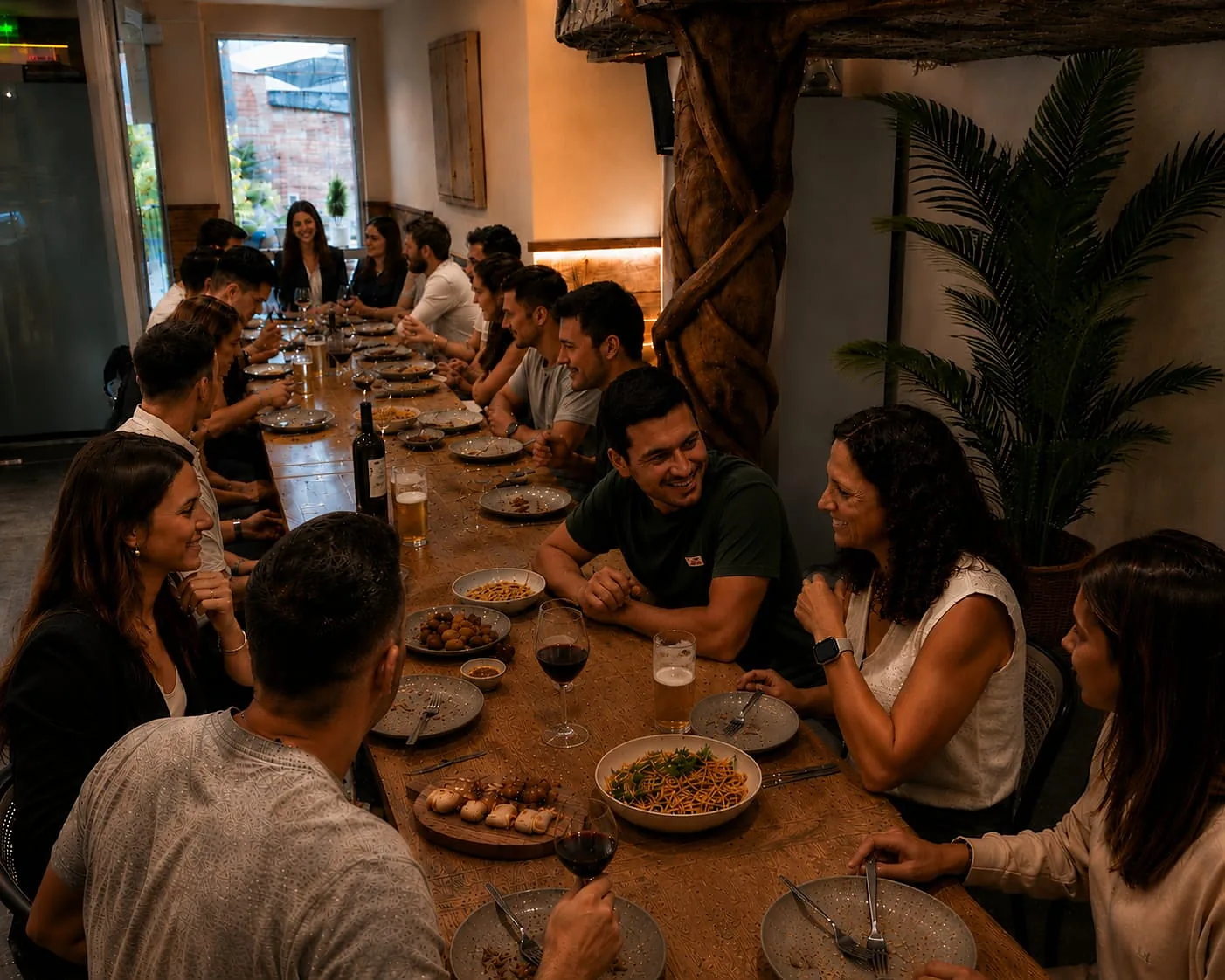 Mesa corrida con más de veinte comensales y las fuentes servidas al centro